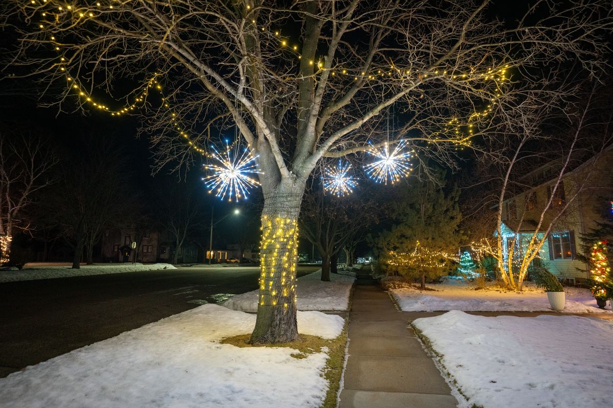 Glowing holiday lights on a winter street — professional outdoor christmas lights installation in a residential neighborhood