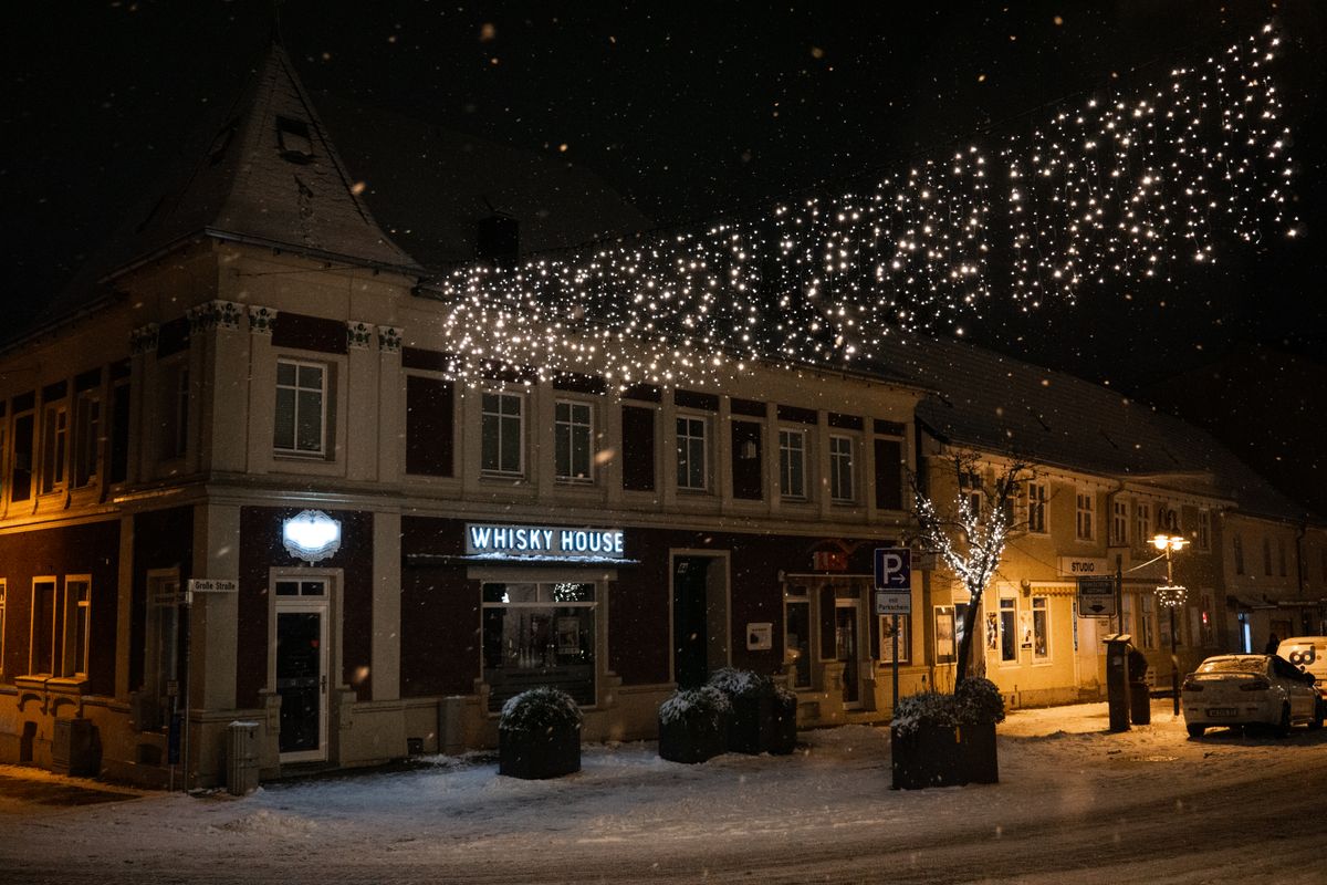 A festive neighborhood with permanent holiday lighting effects on homes at night