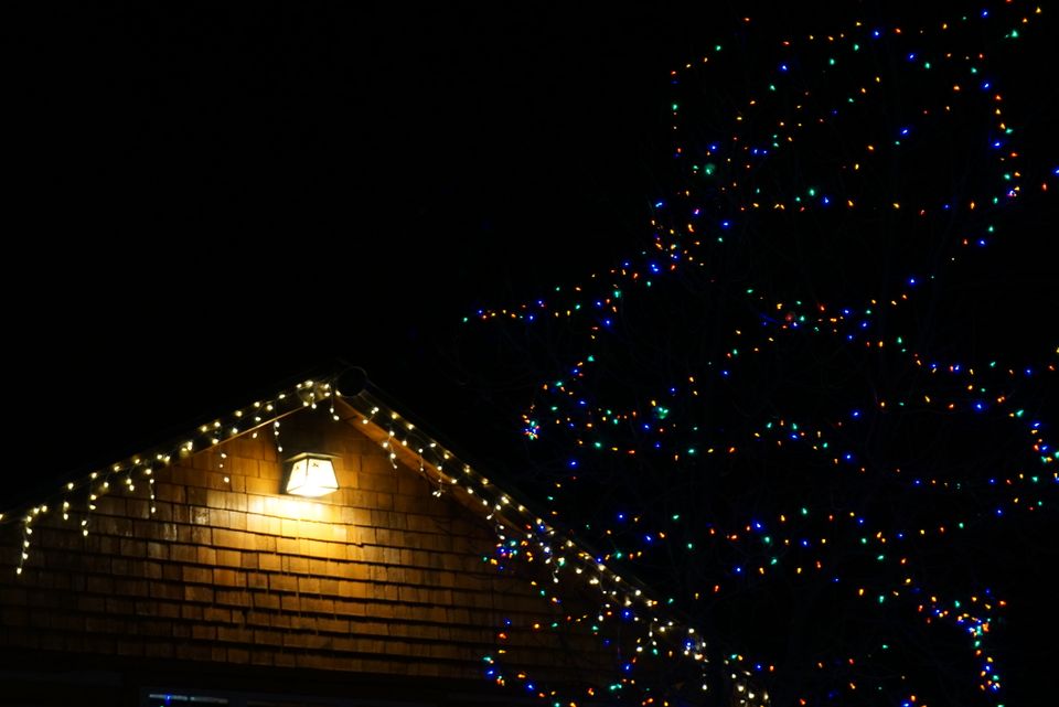 A home covered in colorful outdoor christmas lights at night — the kind of display a professional christmas light installer creates
